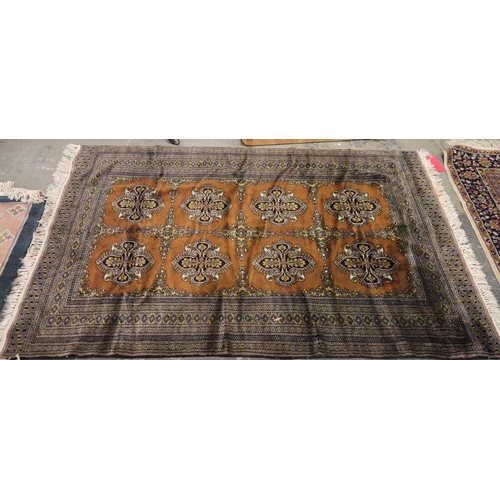 1028 - Eastern brown ground rug with two rows of four floral cross motifs, central hooked diamond border fl... 