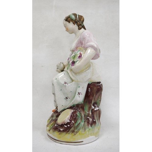 14 - Staffordshire pottery figure of a lady vintner, late 19th century, she modelled seated holding a bas... 