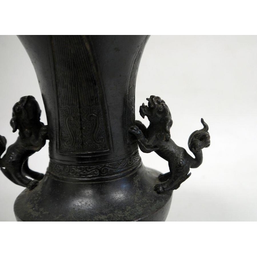 149 - Japanese bronze flared baluster vase, Meiji, applied with two lion dog handles, the body decorated w... 