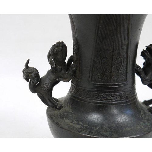 149 - Japanese bronze flared baluster vase, Meiji, applied with two lion dog handles, the body decorated w... 