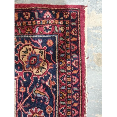 1038 - Persian-style carpet having shaped oval floral central medallion to the maroon ground, cream spandre... 