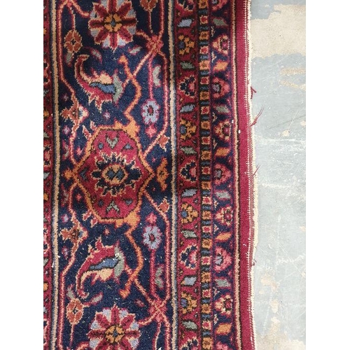 1038 - Persian-style carpet having shaped oval floral central medallion to the maroon ground, cream spandre... 