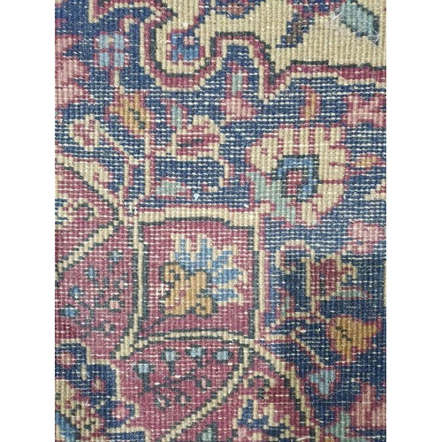 1038 - Persian-style carpet having shaped oval floral central medallion to the maroon ground, cream spandre... 