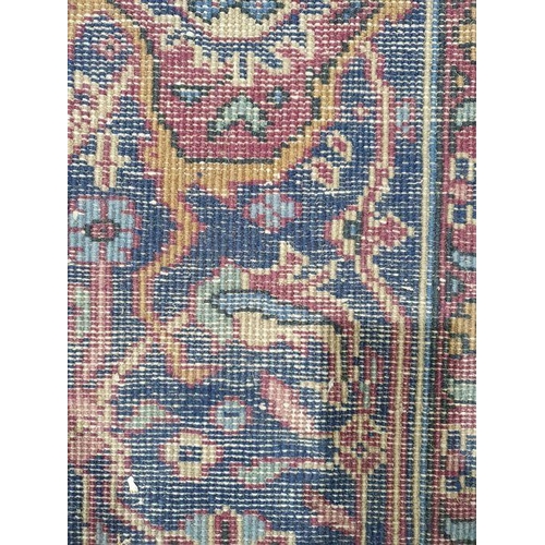 1038 - Persian-style carpet having shaped oval floral central medallion to the maroon ground, cream spandre... 