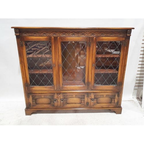 1171 - 20th century oak cabinet, the moulded carved cornice above three leaded glazed doors enclosing shelv... 