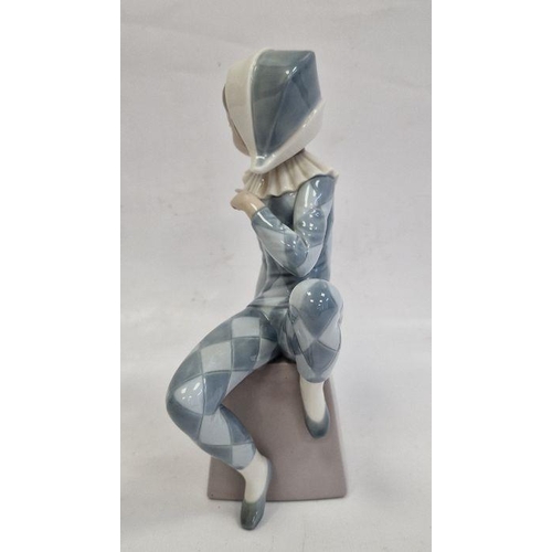 2 - Lladro figure of boy wearing harlequin suit seated on box initialled B, 20.5cm high