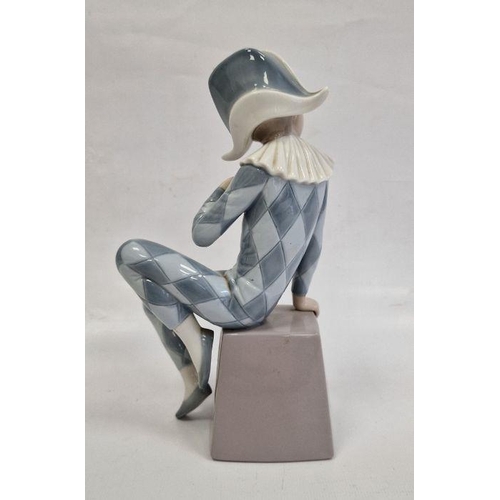 2 - Lladro figure of boy wearing harlequin suit seated on box initialled B, 20.5cm high