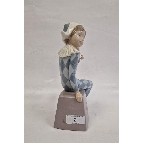 2 - Lladro figure of boy wearing harlequin suit seated on box initialled B, 20.5cm high