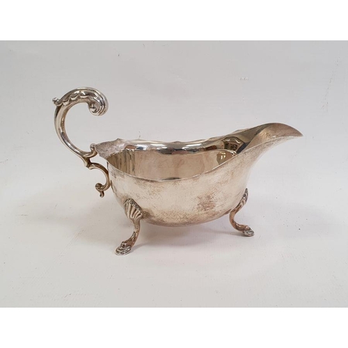 257 - Silver sauceboat with serpentine everted rim, free C-scroll handle, shell and step pad feet, Birming... 