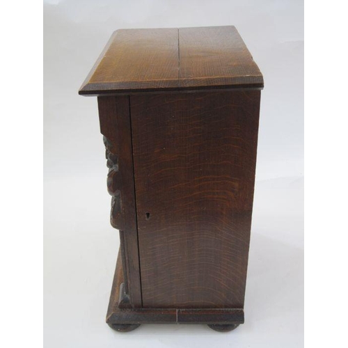 336 - Early 20th century oak smoker's cabinet, the framed panel door carved with foliate and lozenge, flan... 