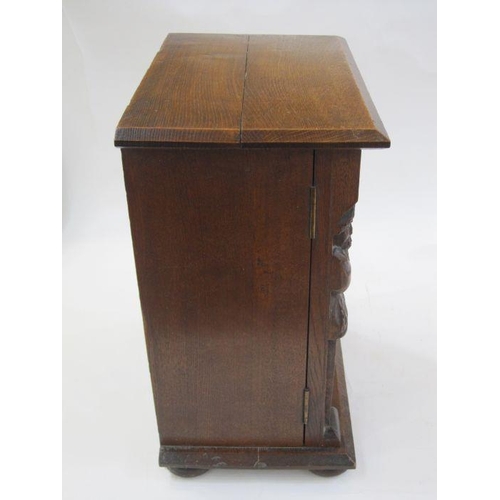 336 - Early 20th century oak smoker's cabinet, the framed panel door carved with foliate and lozenge, flan... 