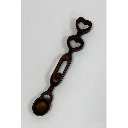 135 - 19th century Welsh love spoon, the handle containing a ball surmounted by two hearts