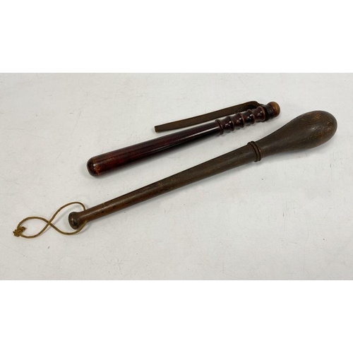 152 - Carved wooden truncheon and another, 50cm and 39cm (2)