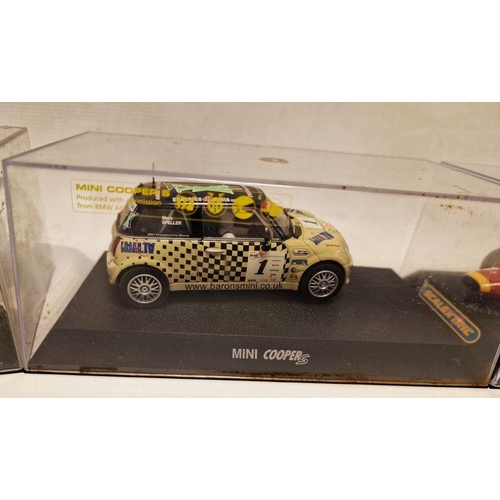 535 - Four cased Scalextric slot cars to include Mini Cooper S Marked 17A, Mini Cooper S marked 1, Aston M... 