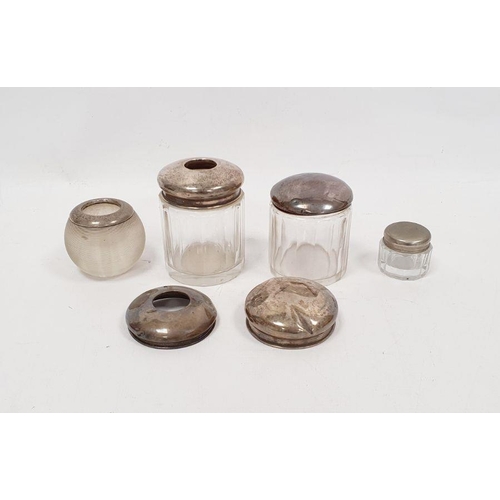 336 - Two silver lidded glass jars, a silver-mounted candlestick holder, two loose silver lids and a silve... 