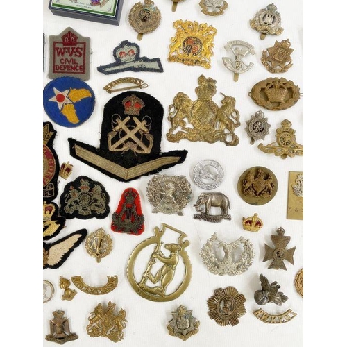 264 - Collection of British military cap badges, cloth badges and rank markings