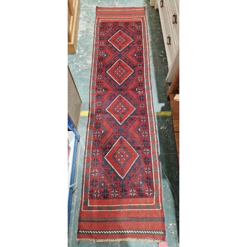 1026 - Meshwani red ground wool runner with one row of four diamond medallions and multiple geometric borde... 