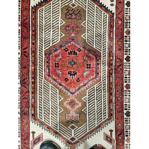 1032 - North West Persian Heriz cream ground runner with central lozenge medallion flanked by two larger ge... 