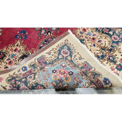 1057 - North East Persian Signed red ground Meshed carpet with large centralised floral medallion enclosed ... 