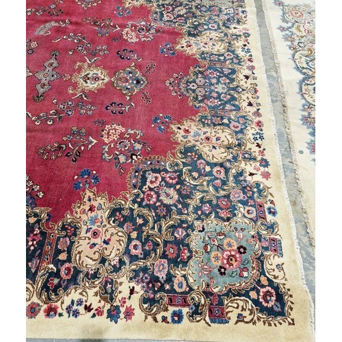 1057 - North East Persian Signed red ground Meshed carpet with large centralised floral medallion enclosed ... 