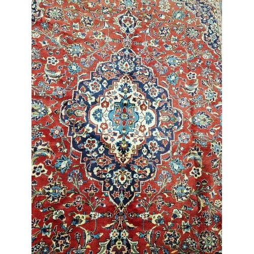 1060 - Central Persian Kashan red ground carpet with central floral medallion enclosed by floral pattern to... 