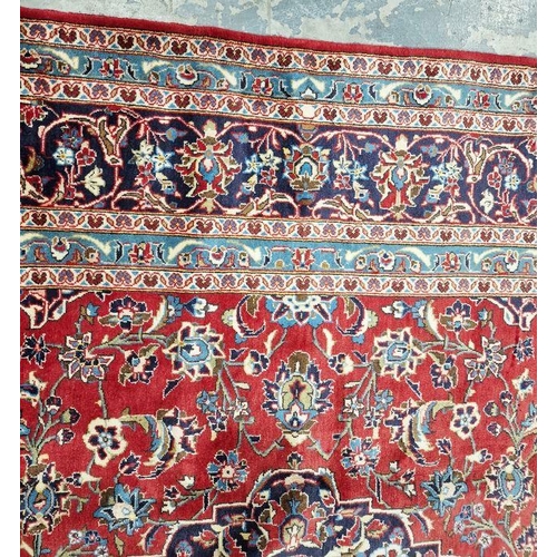 1060 - Central Persian Kashan red ground carpet with central floral medallion enclosed by floral pattern to... 