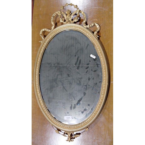 1321 - Oval gilt-framed mirror with scroll and floral decoration, 68cm