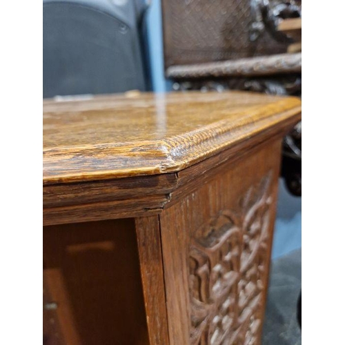 1243 - Early 20th century carved oak revolving bookcase of octagonal form, the four-side panels adourned wi... 