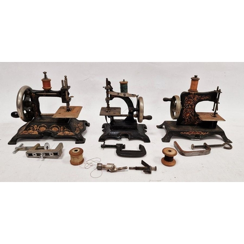 83 - Collection of four early 20th century child's sewing machines, tinplate and cast iron, black with go... 