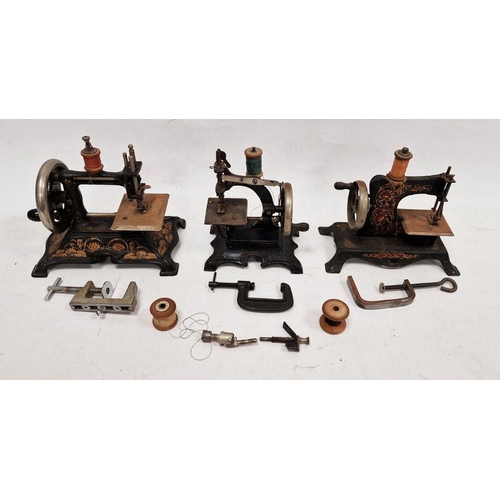 83 - Collection of four early 20th century child's sewing machines, tinplate and cast iron, black with go... 