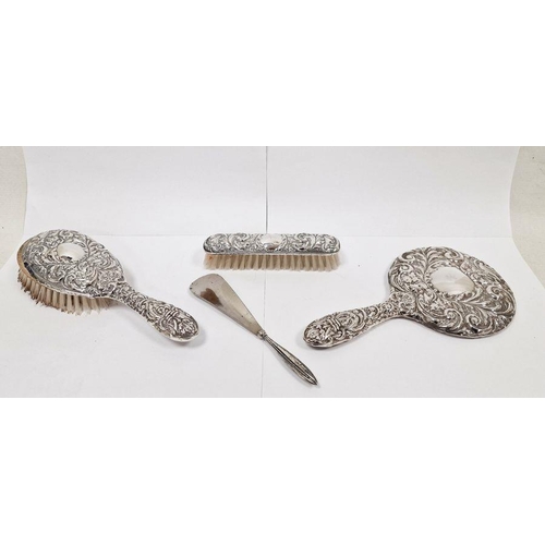 306 - Three-piece silver-mounted dressing set comprising of two brushes and a mirror, repousse decorated, ... 