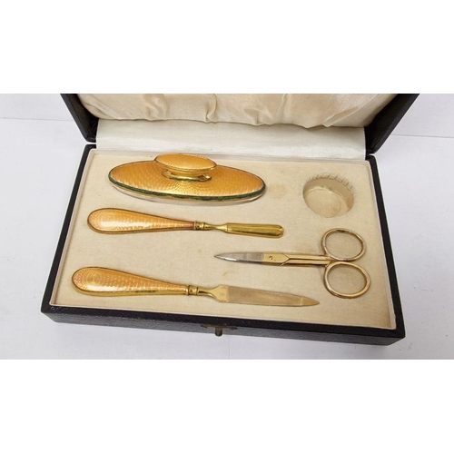 375 - Gilt-coloured metal and orange enamel manicure set in fitted box