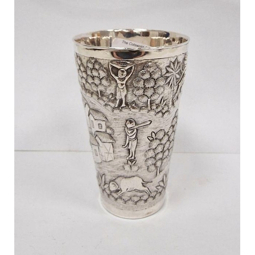 379 - Foreign silver-coloured metal cup with relief of village and figures, initialled to base 'D.M.D', un... 