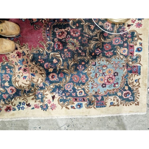 1053 - North East Persian signed red ground Meshed carpet with large centralised floral medallion enclosed ... 