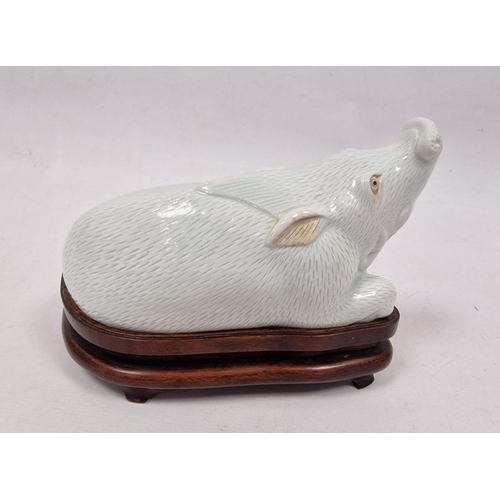 175 - Chinese Export style white glazed porcelain model of a boar on wooden stand, kneeling, in the Qianlo... 