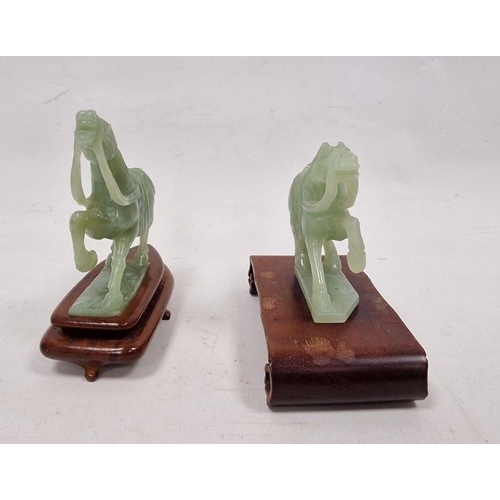 176 - Two various carved jade horses, each with raised foreleg, 9cm high and the hardwood stands (some dam... 