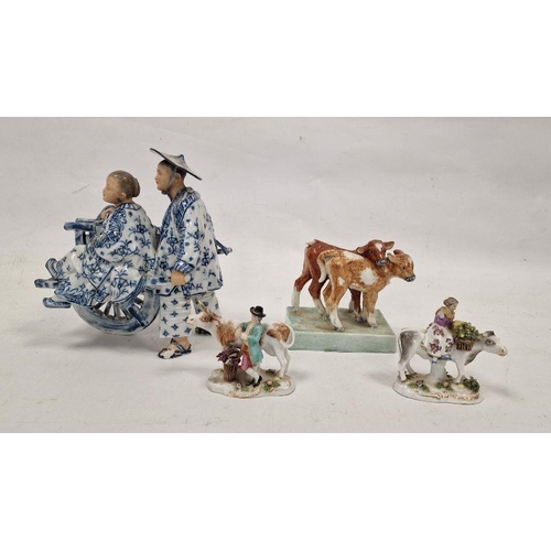 74 - Pair of German small porcelain figures with cattle, modelled carrying baskets of grapes and flowers,... 