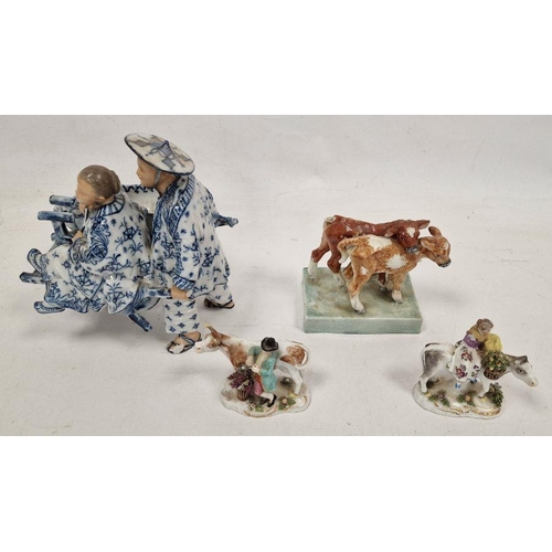 74 - Pair of German small porcelain figures with cattle, modelled carrying baskets of grapes and flowers,... 