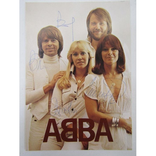 121 - Signed ABBA publicity card featuring a photograph of all four members of the band, signed by each.