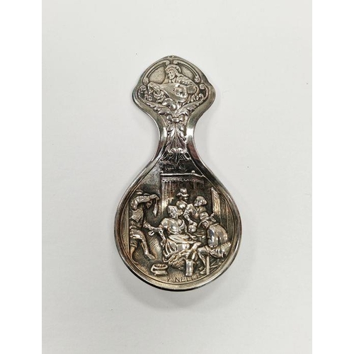 494 - Continental white metal tea caddy spoon with embossed deoration depicting a traditional 19th century... 