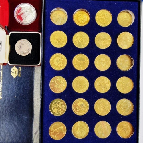 752 - Collection of 23 tokens representing the XXIIIrd Olympiad Los Angeles 1984, some damage to the inner... 