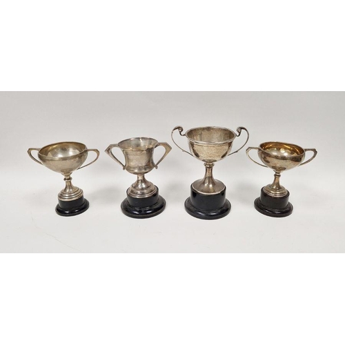 329 - Four early 20th century unengraved silver trophies, each being twin-handled and raised on pedestal, ... 
