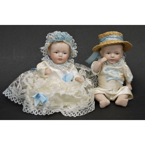 86 - Pair of German small biscuit porcelain dolls with articulated head and limbs, dressed in matching sa... 