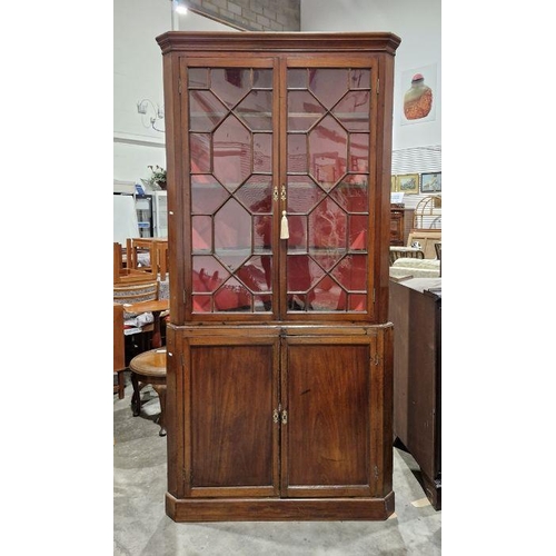 1053 - Late Georgian mahogany standing corner cupboard in two sections, the upper section enclosed by glaze... 