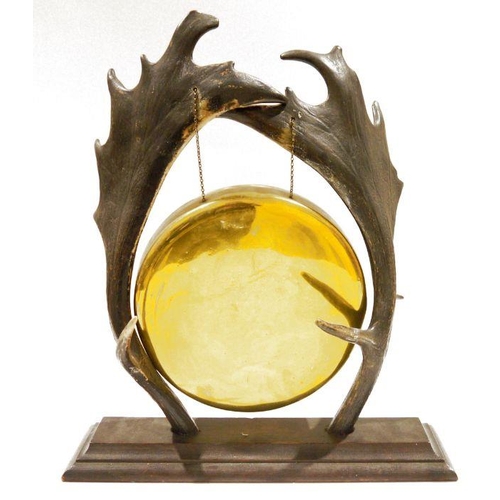 107 - Early 20th century brass dinner gong suspended from an antler stand, the antlers pierced and suspend... 