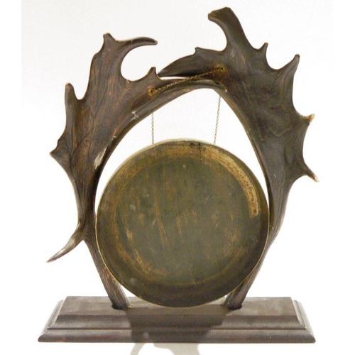 107 - Early 20th century brass dinner gong suspended from an antler stand, the antlers pierced and suspend... 