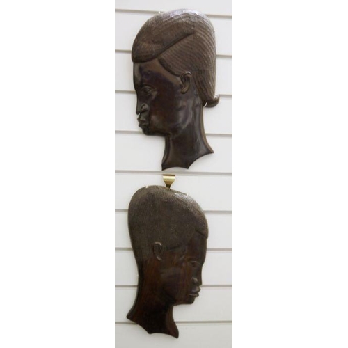 92 - Pair of 20th century African carved hardwood wall hangings of man and woman in profile, 38.5cm high ... 