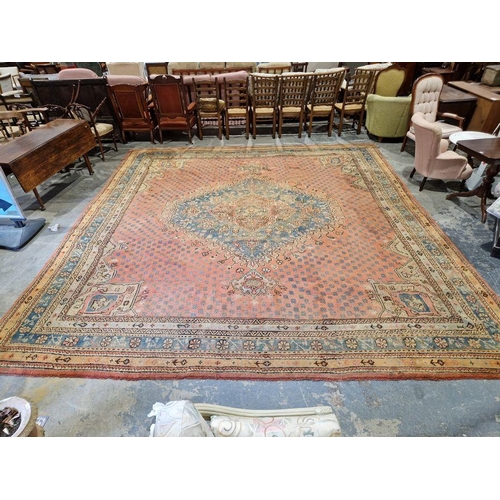 1033 - Large antique Heriz handmade wool pile carpet pink ground, with central hexagonal geometric medallio... 