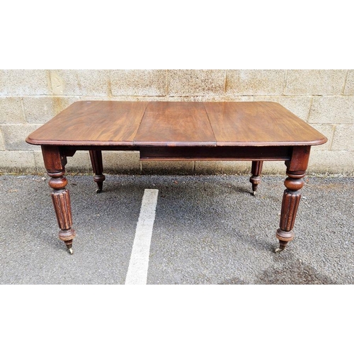 1112 - Victorian mahogany extending dining table on four turned legs, raised on metal castors, with one add... 