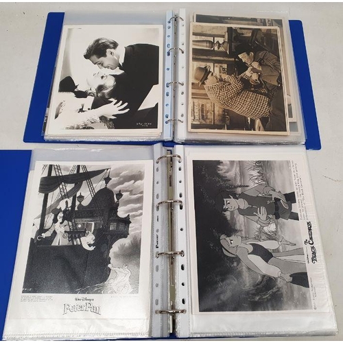 270 - Two folders of official publicity film stills to include Westerns, Disney, Laurel & Hardy, Charlie C... 